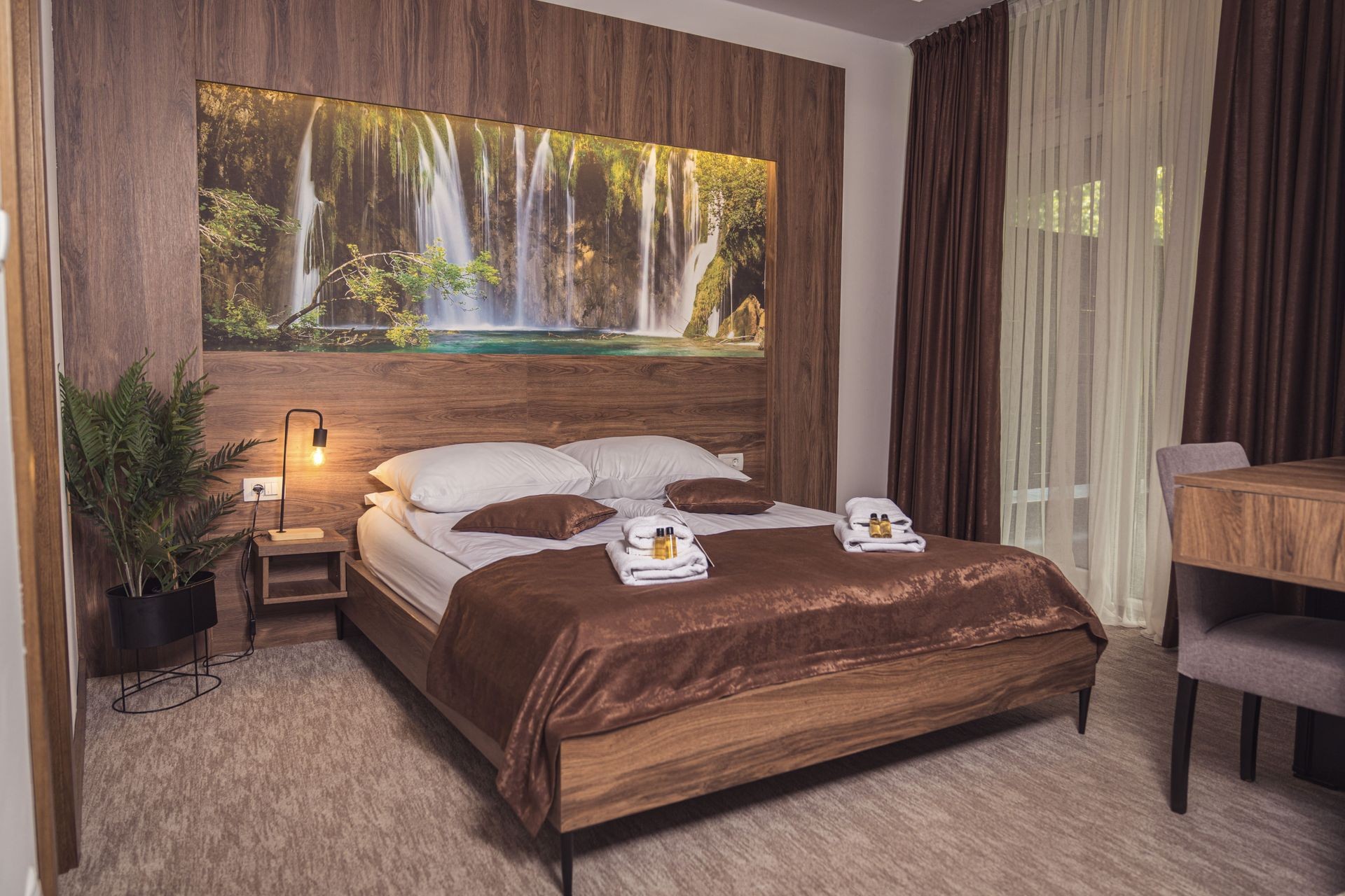"Elegant hotel room with nature-themed wall art and warm brown tones in Hotel Tazz in Bihać, Bosnia"