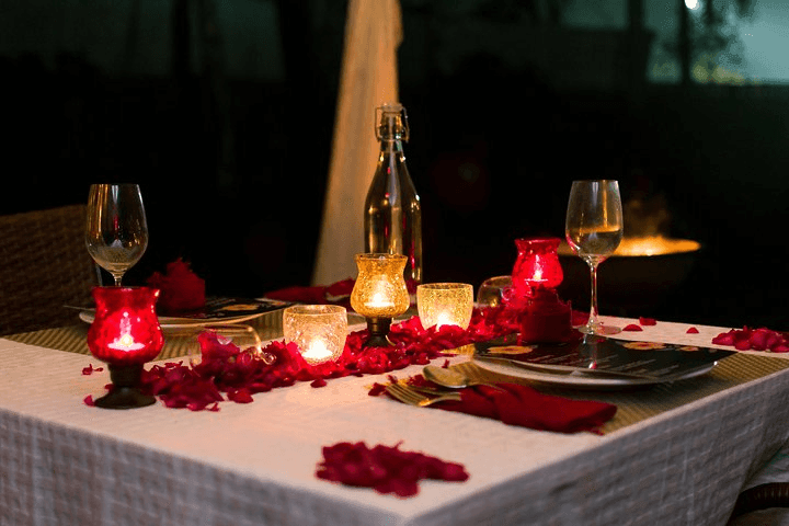 private dinner, glasses, roses, candles on the table